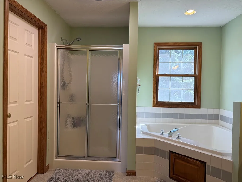 Bathroom featuring a garden tub, a stall shower, and recessed lighting
