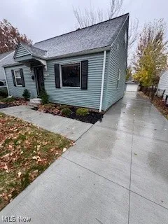 Bungalow-style home with concrete driveway and a shingled roof