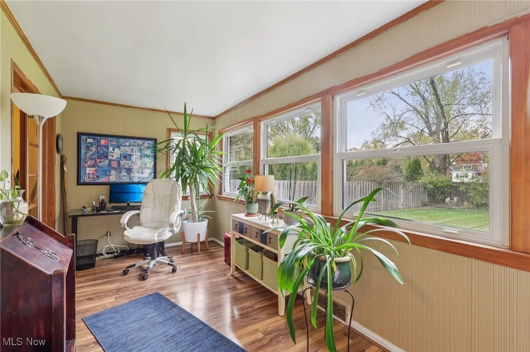 Office featuring ornamental molding, wooden walls, and light wood-style flooring
