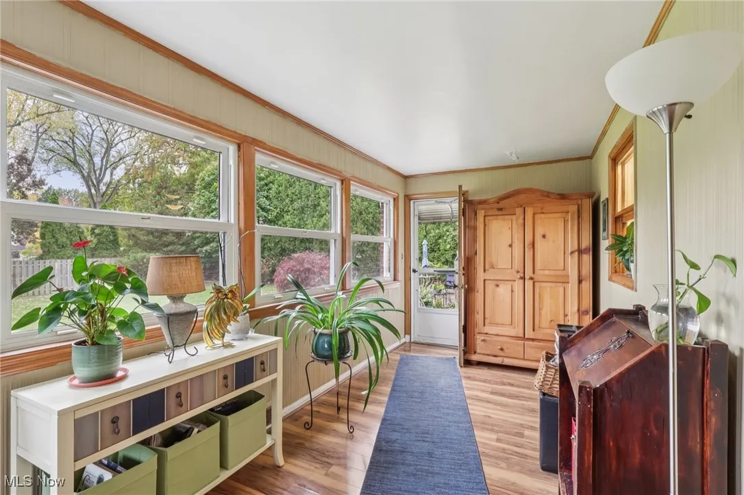 Sunroom / solarium with wood finished floors and ornamental molding