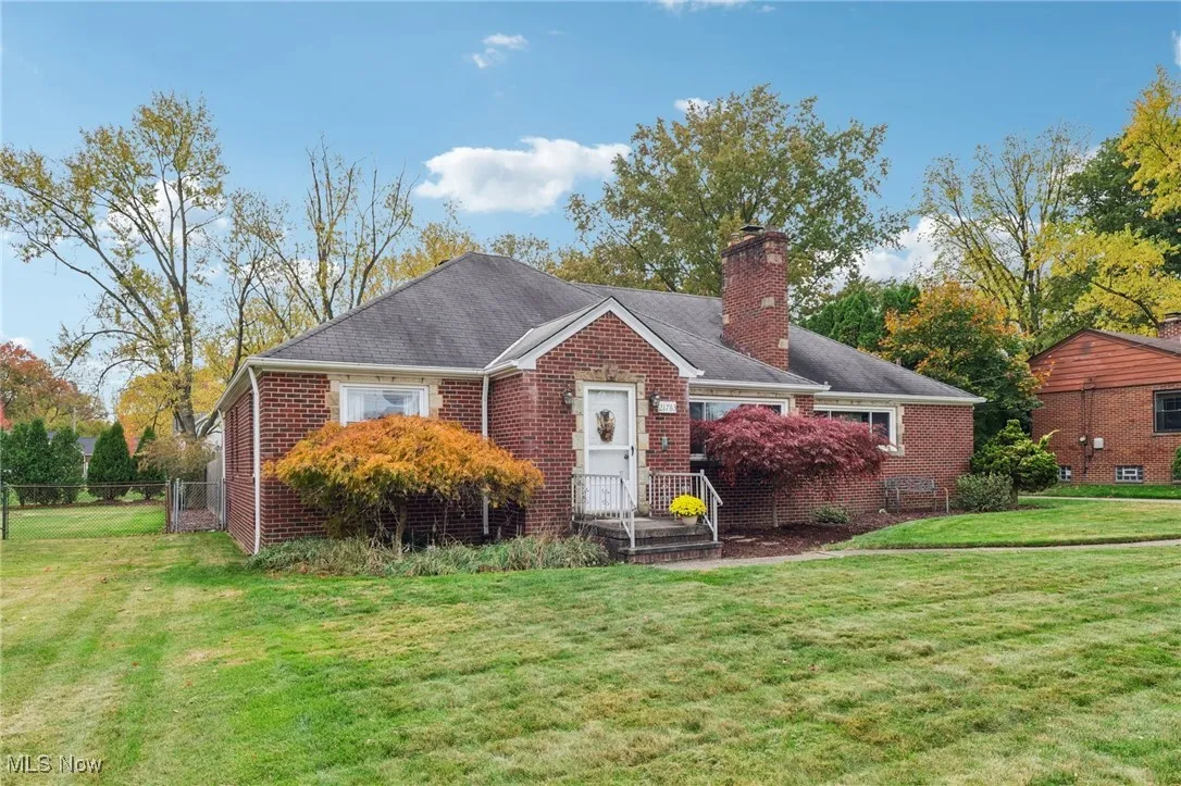 View of front of house with a chimney, brick siding, and a shingled roof