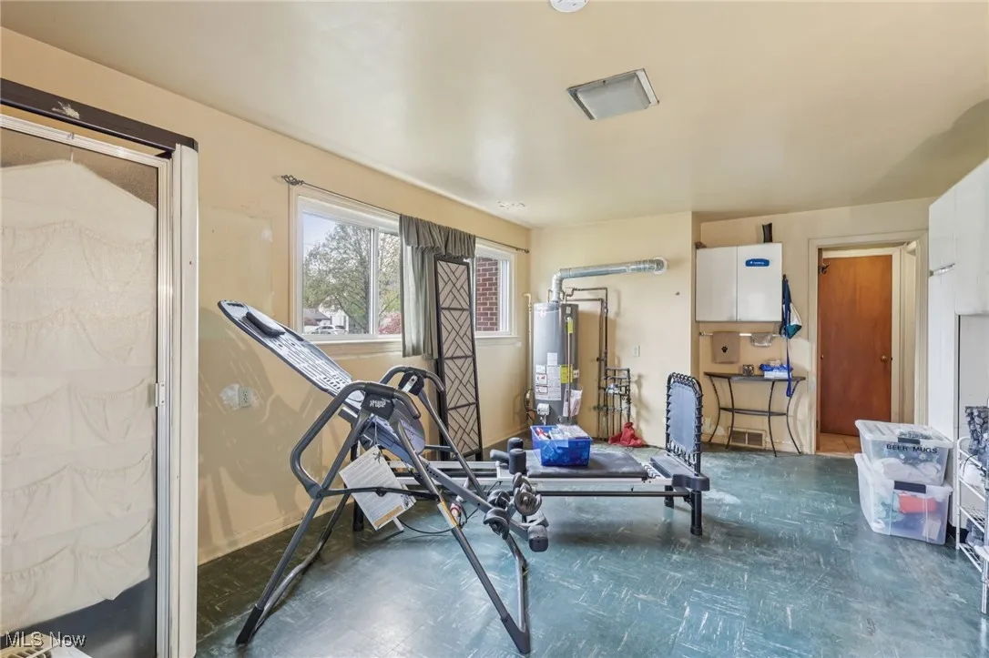 Exercise area with dark flooring and water heater