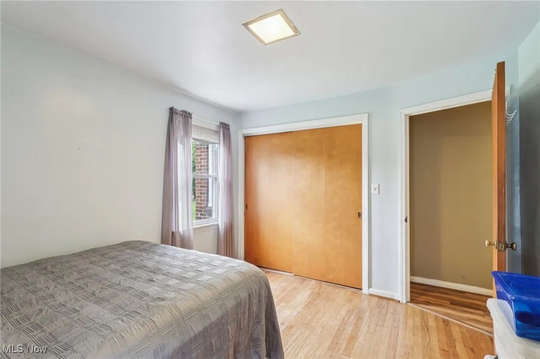 Bedroom with wood finished floors and a closet
