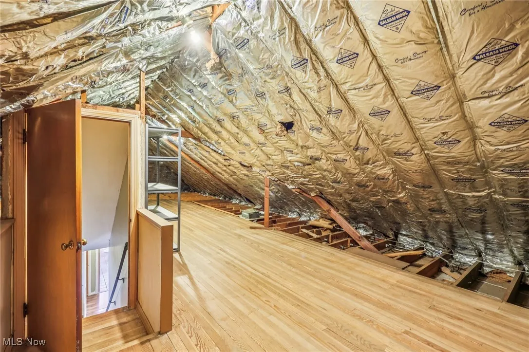 Unfinished attic featuring an upstairs landing
