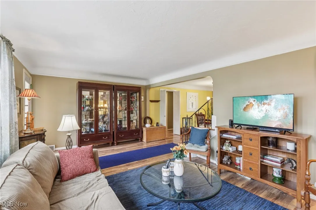 Living area with wood finished floors, stairs, and arched walkways