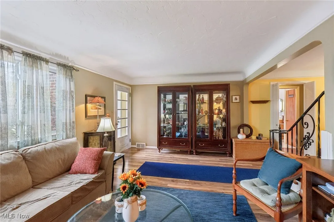 Living room featuring wood finished floors, plenty of natural light, and stairs