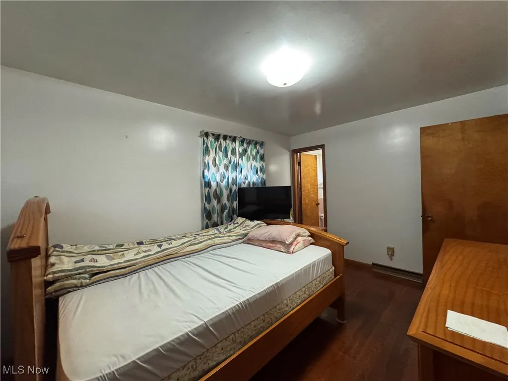 Bedroom featuring dark wood finished floors and baseboard heating
