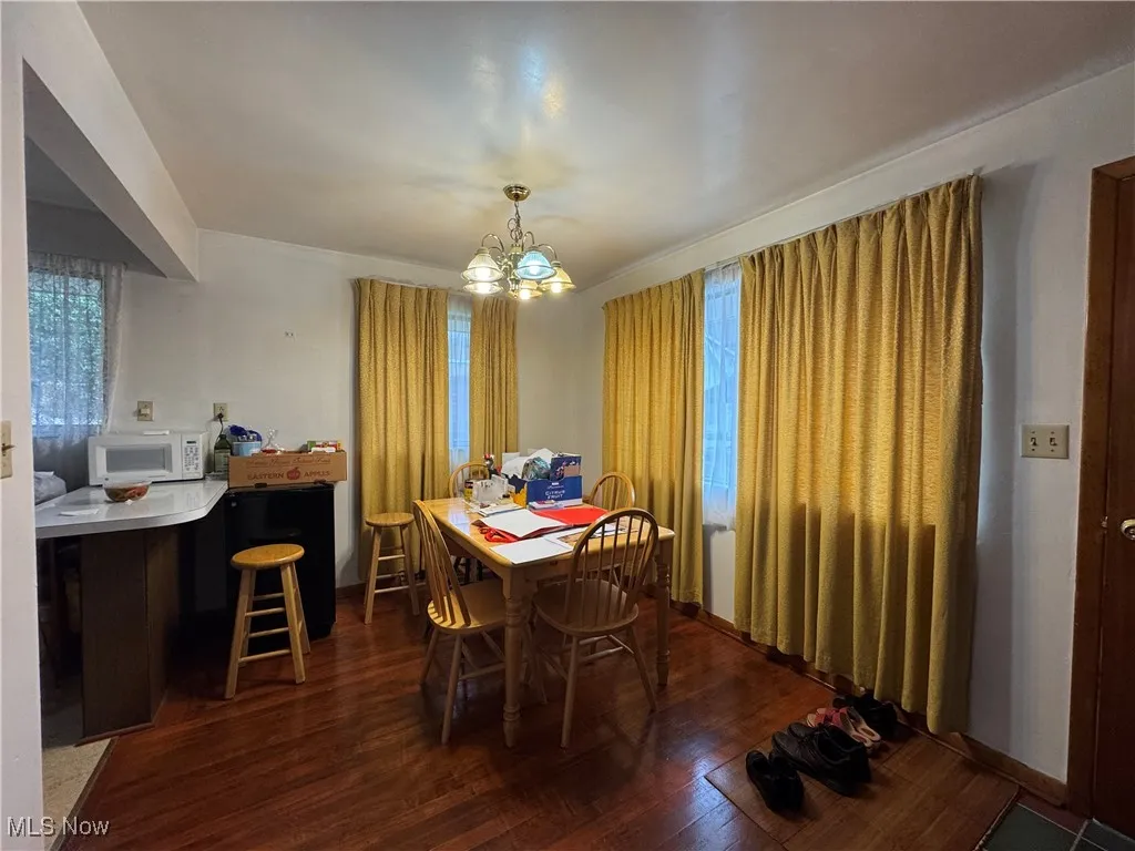 Dining area featuring dark wood finished floors and a chandelier