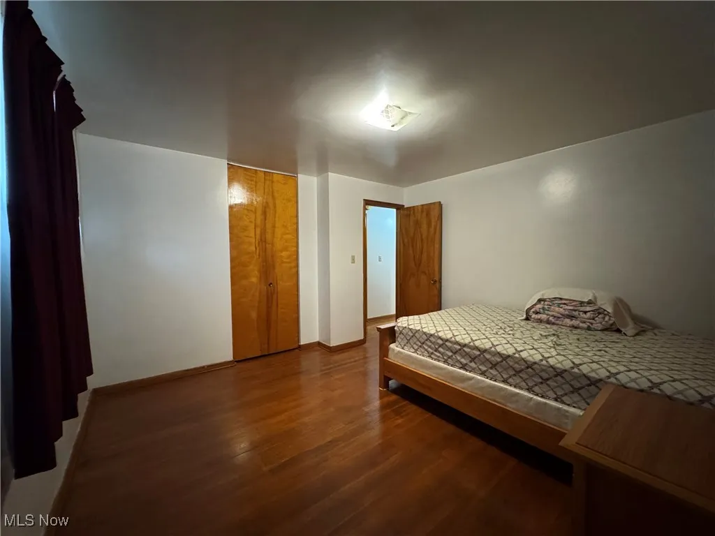 Bedroom featuring wood finished floors and a closet
