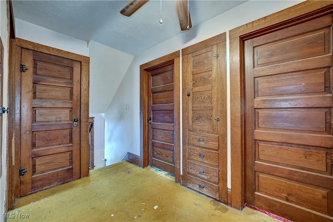 Bedroom featuring a closet, vaulted ceiling, a textured ceiling, a ceiling fan, and concrete flooring