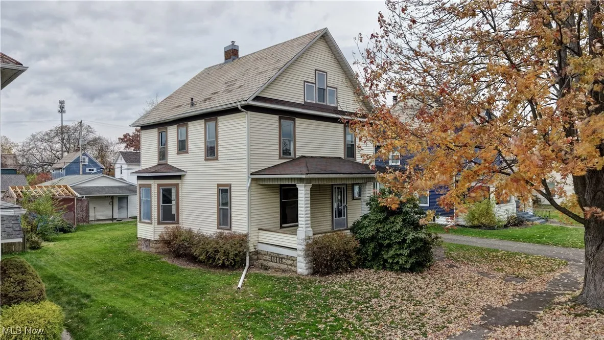 Back of property featuring a lawn, a porch, and a chimney