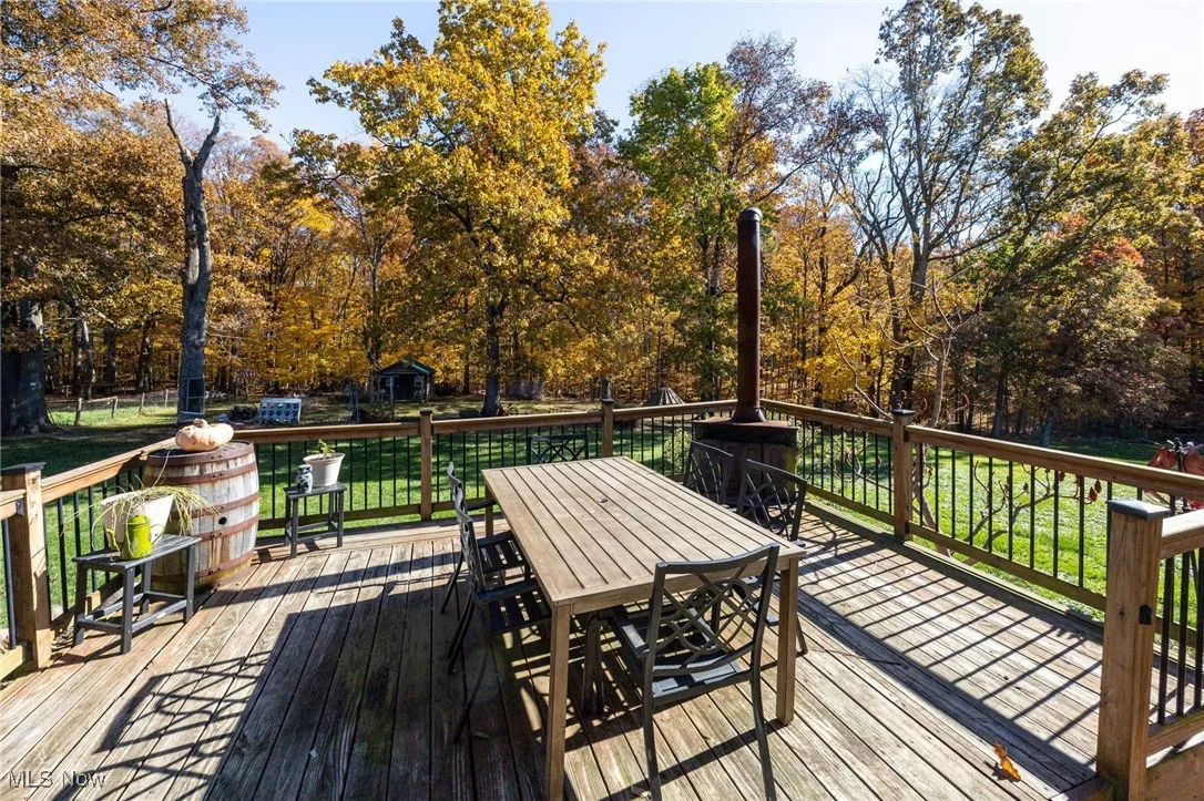 Wooden deck featuring outdoor dining area and a yard