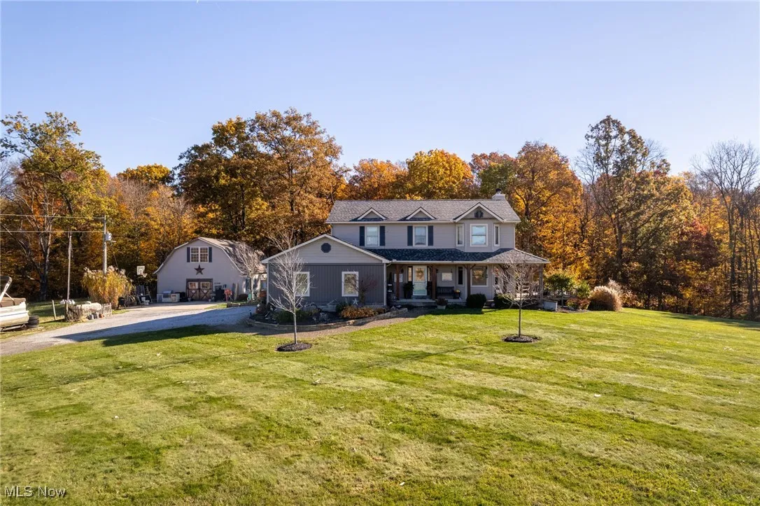 View of front of house with a porch, a front yard, and driveway