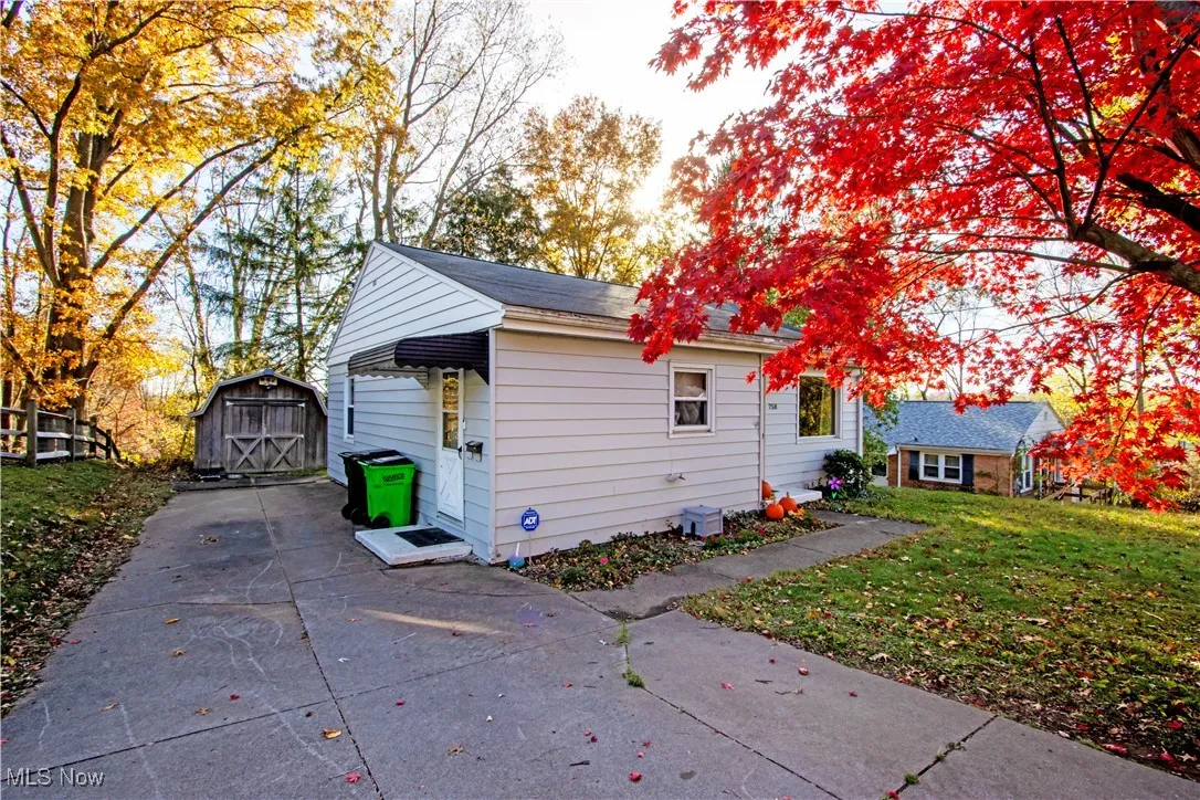 View of home's exterior with a lawn and a storage shed