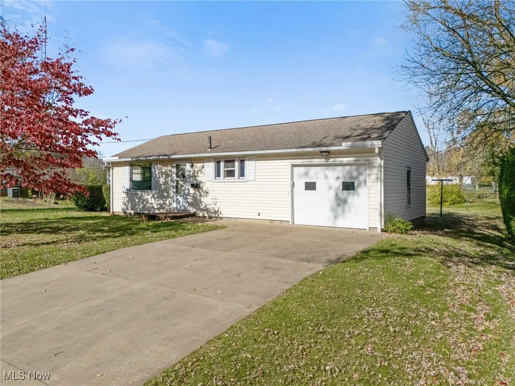 View of front of house with driveway, a front lawn, and a garage