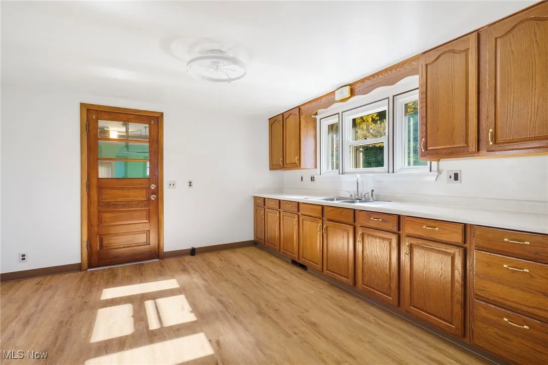 Kitchen featuring brown cabinets, light countertops, and light wood-style floors