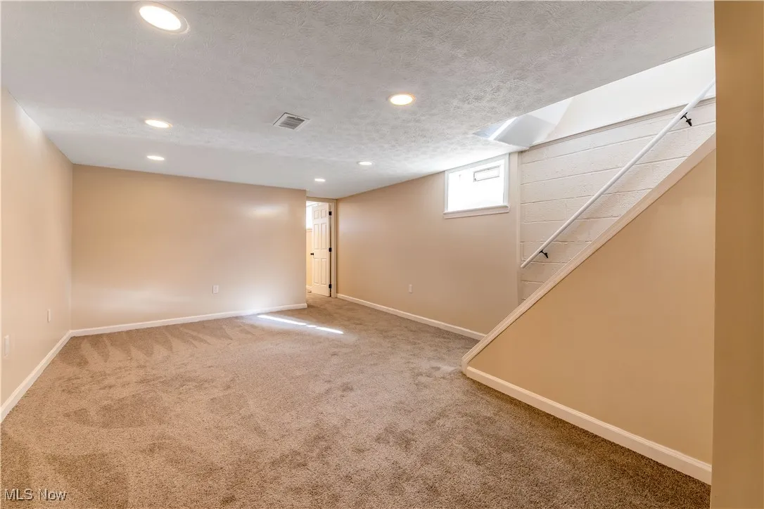 Recreation Room with carpet,  recessed lighting, glass block windows and a textured ceiling.