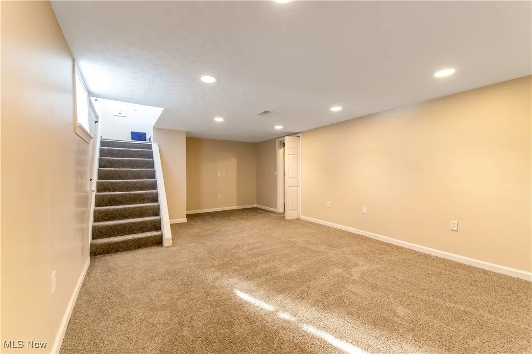 Finished basement featuring recessed lighting, and carpet.