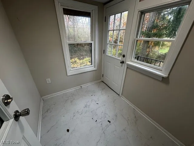 Entryway featuring healthy amount of natural light and marble finish flooring