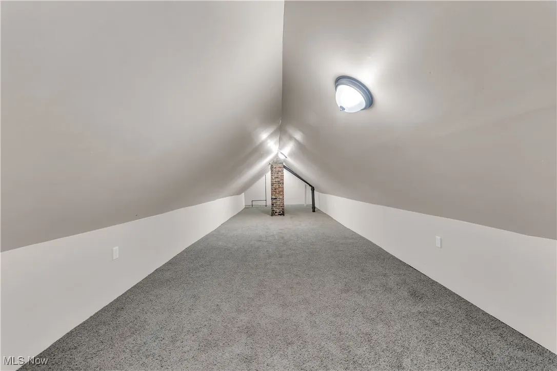 Additional living space with lofted ceiling and carpet