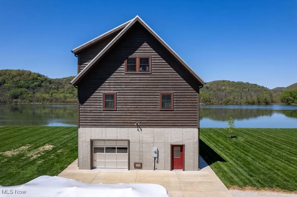 Road side of home as seen from back part of land seen from showing parking pad and distant view of river