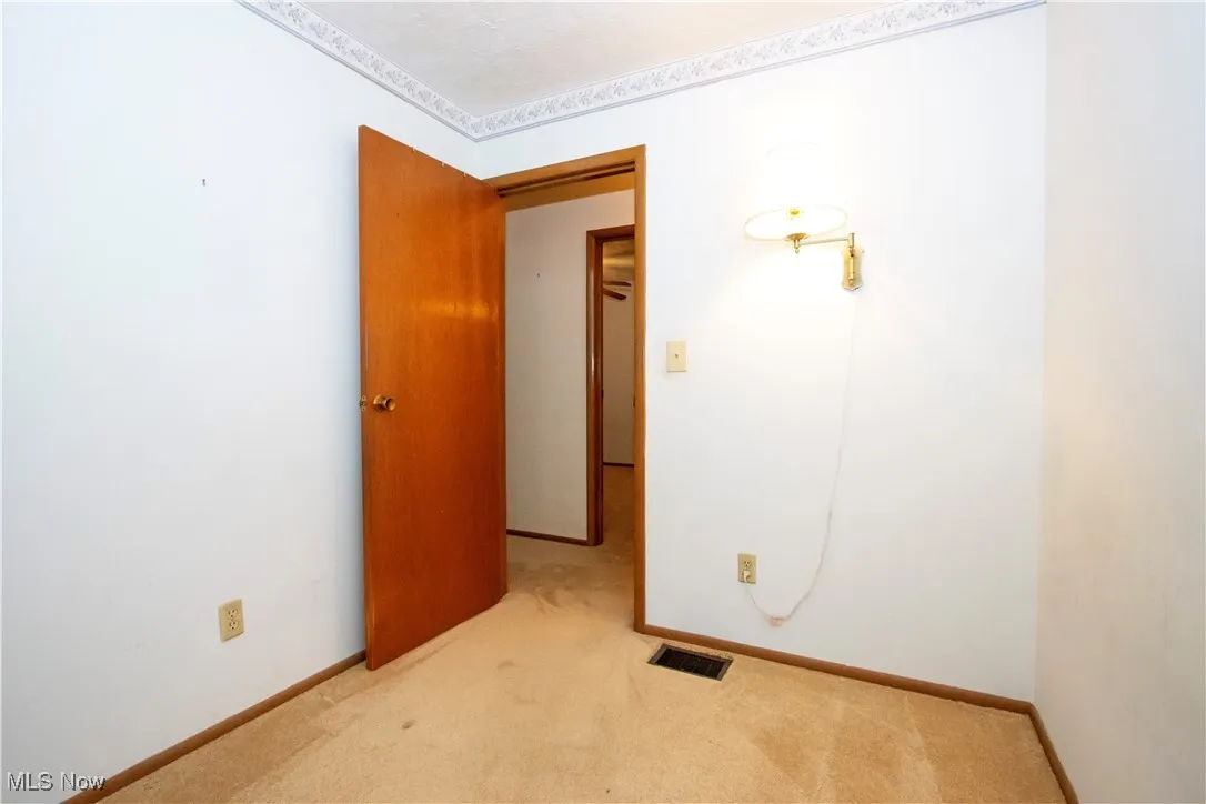 Empty room with light carpet and baseboards
