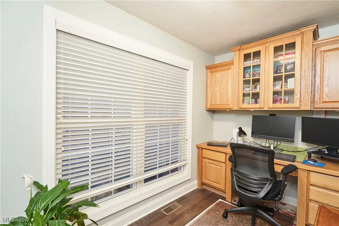 Office with dark wood-style floors, a textured ceiling, and built in study​​‌​​​​‌​​‌‌​‌‌​​​‌‌​‌​‌​‌​​​‌​​ area