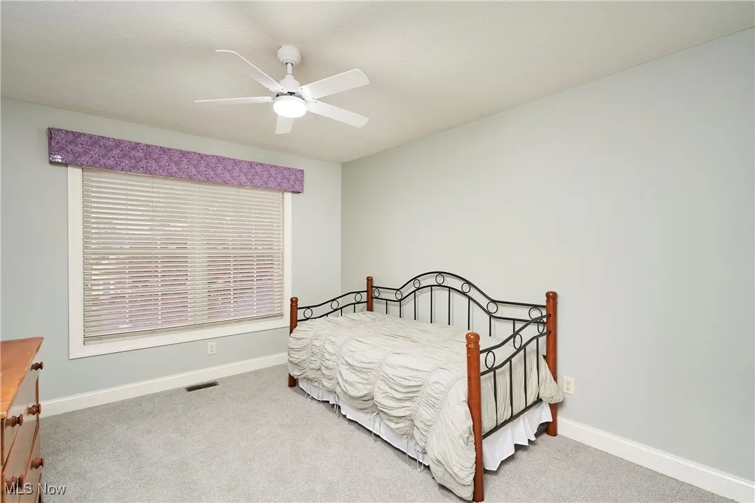 Bedroom with light colored carpet and ceiling fan