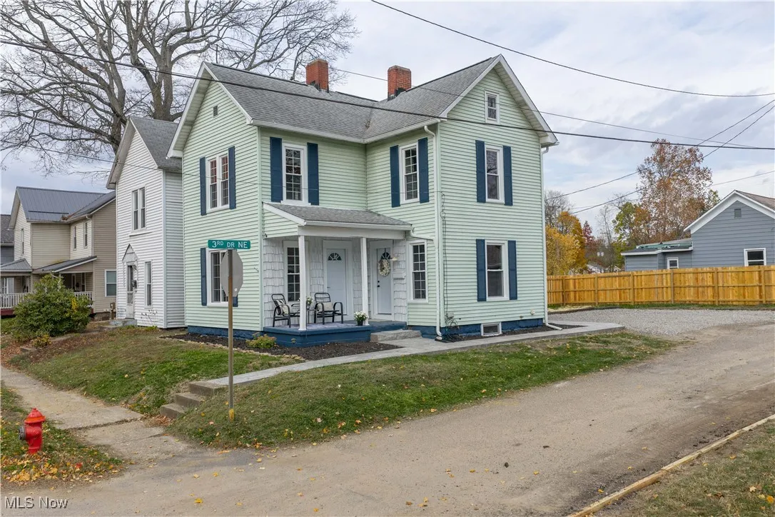 Traditional-style house featuring a chimney, covered porch, and roof with shingles
