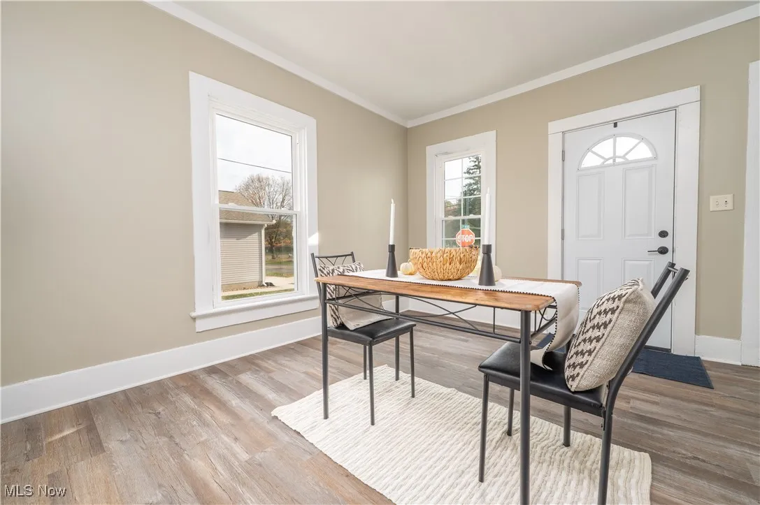 Dining space featuring ornamental molding, wood finished floors, and a desk