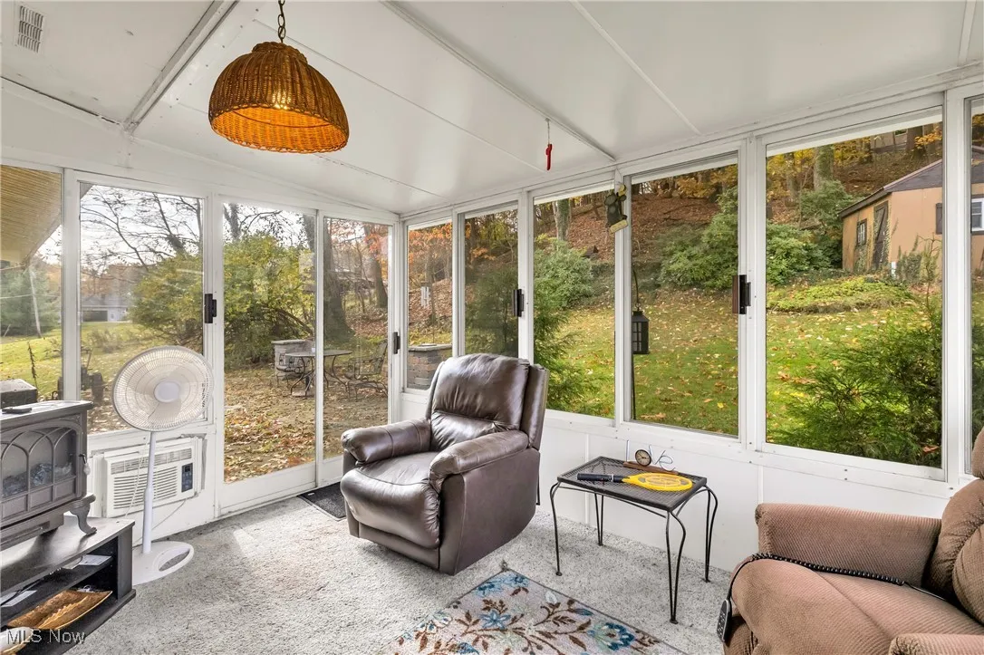 Sunroom / solarium with a wood stove and vaulted ceiling