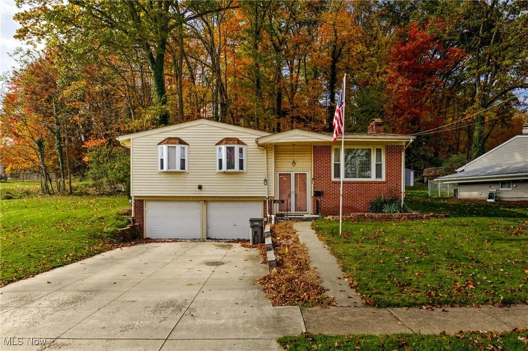 View of front of home with a front lawn, brick siding, and concrete driveway