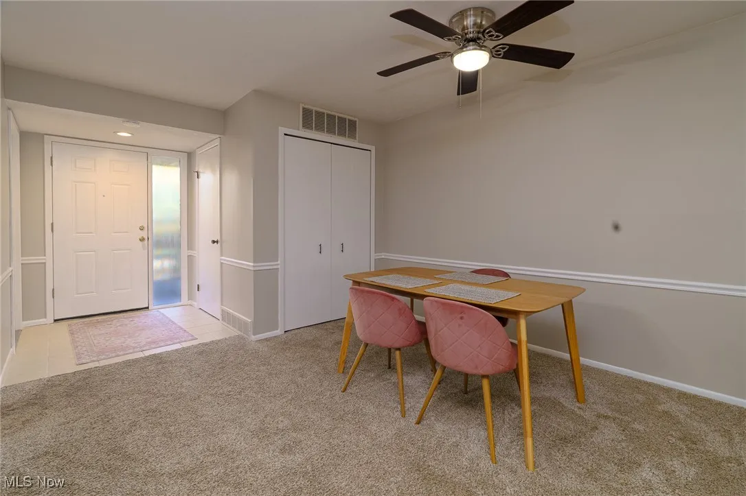 Dining space featuring light colored carpet, light tile patterned floors, and ceiling fan