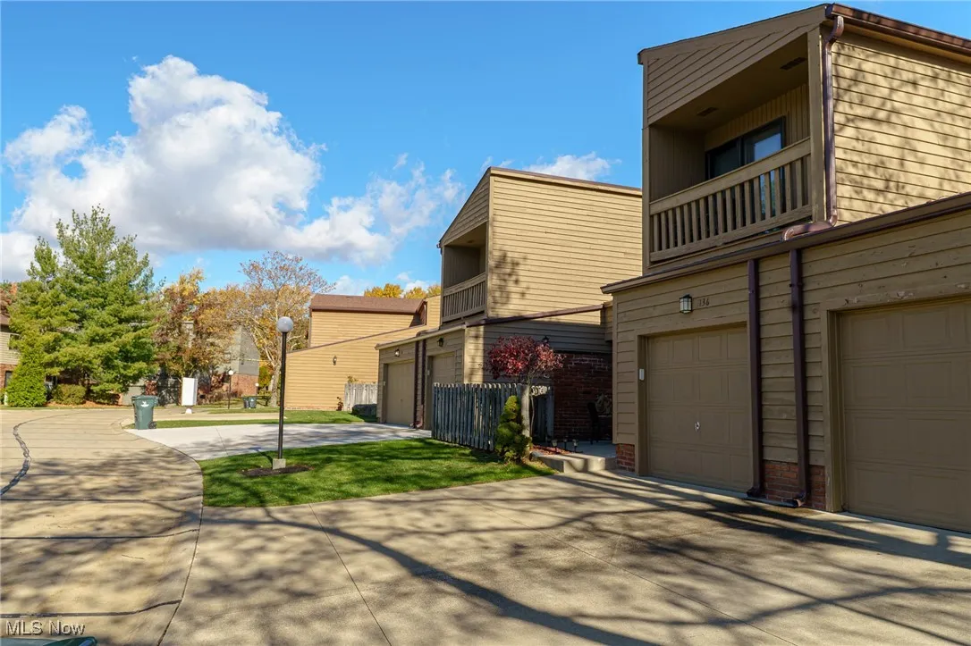 View of side of property with a balcony and concrete driveway