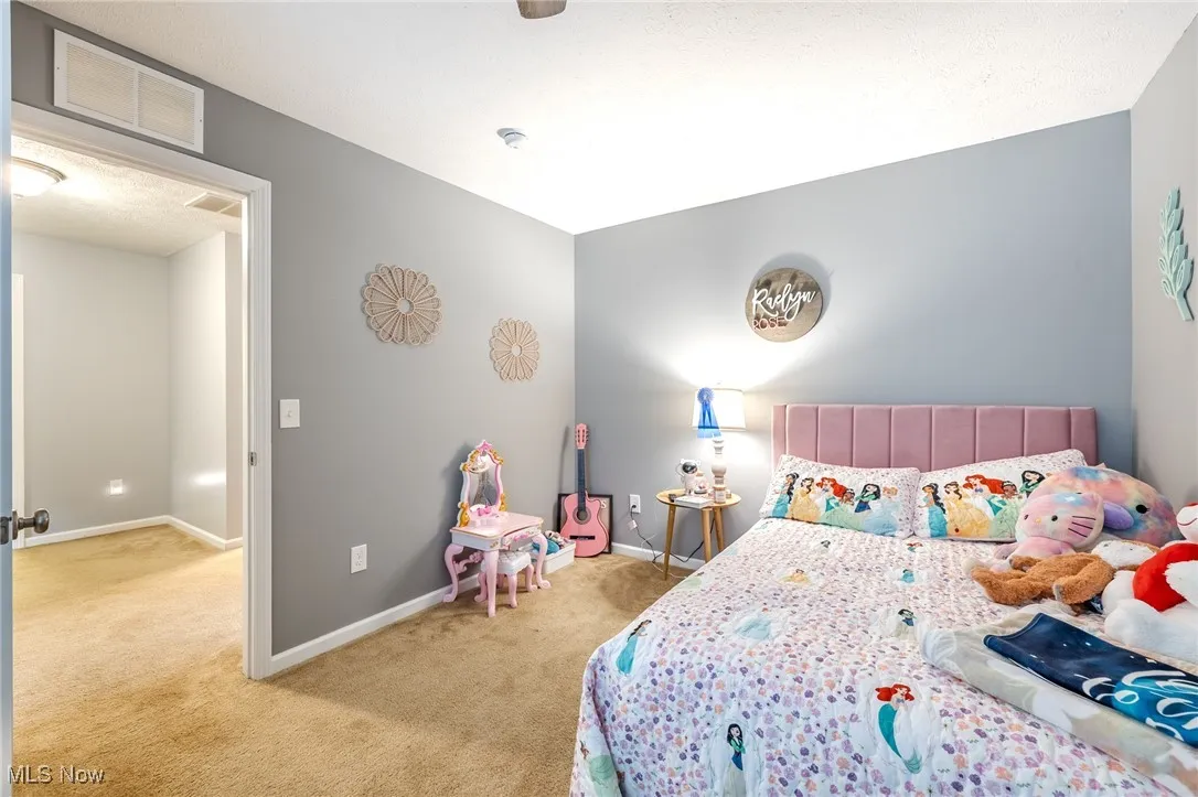 Bedroom featuring light carpet and a textured ceiling