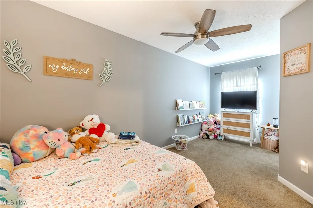 Bedroom with light carpet and ceiling fan