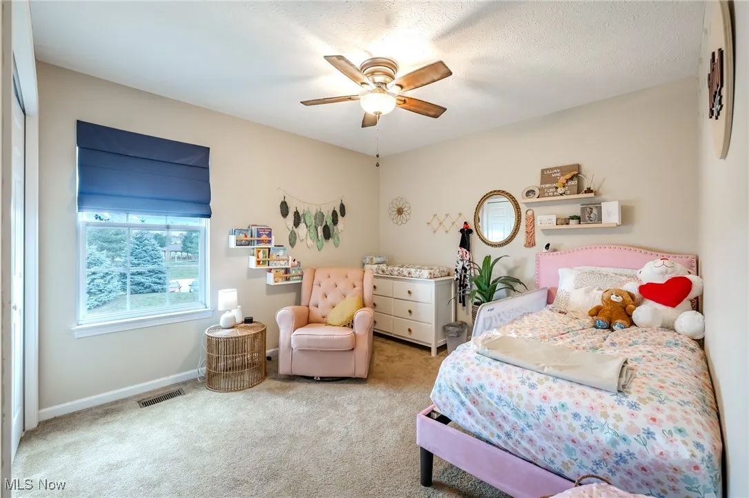 Bedroom featuring carpet flooring, ceiling fan, and a textured ceiling