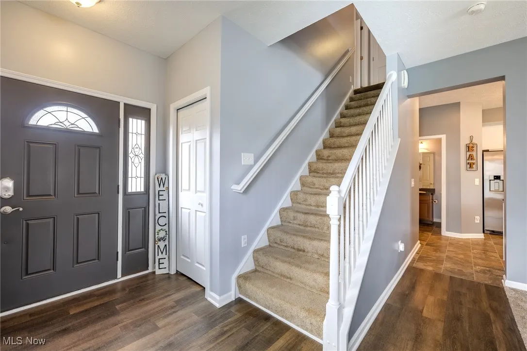 Foyer entrance with stairway and dark wood-style floors