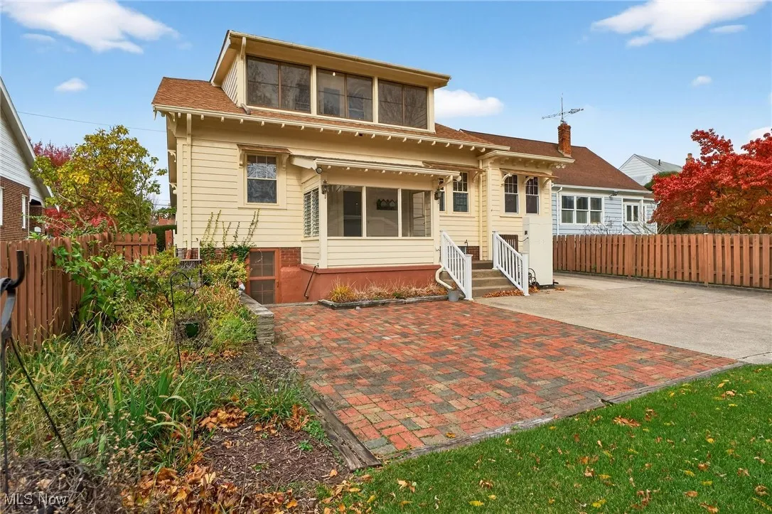 Rear view of house featuring entry steps, a shingled roof, and a patio area