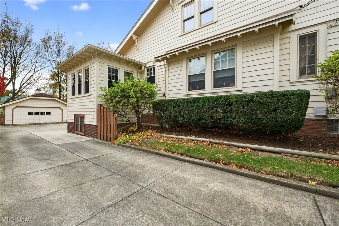 View of side of property with an outbuilding and a detached garage