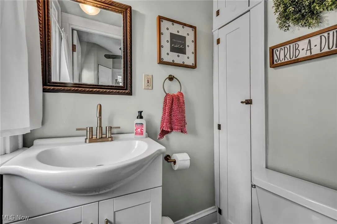 Half bath with vanity and baseboards