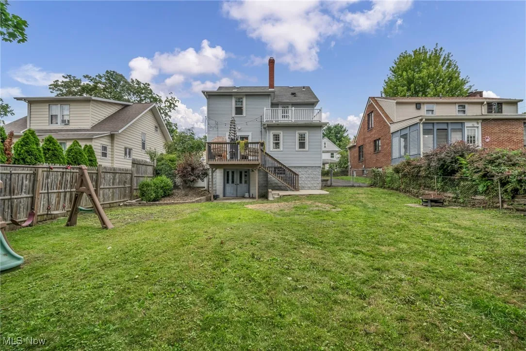 Back of house with stairs, a fenced backyard, a chimney, and a deck