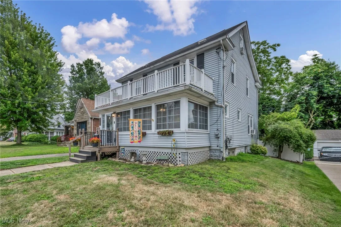 Traditional-style house with a front yard and a balcony