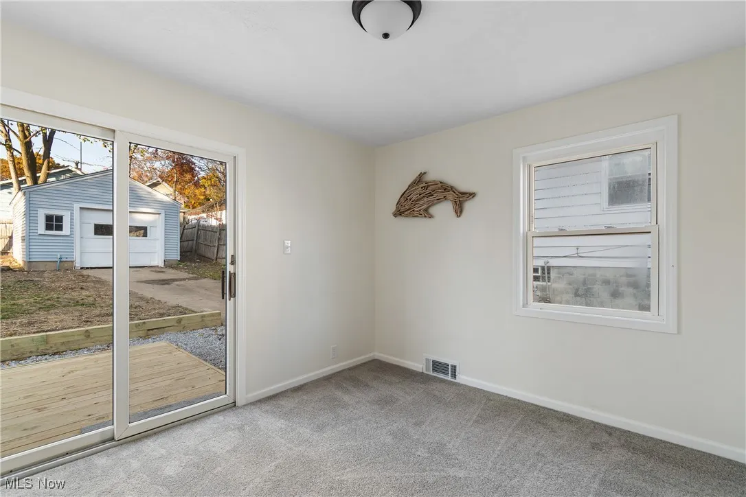 Spare room featuring light colored carpet and baseboards