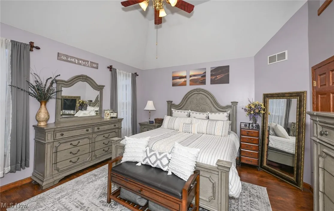 Bedroom featuring dark wood-style flooring, a ceiling fan, and high vaulted ceiling