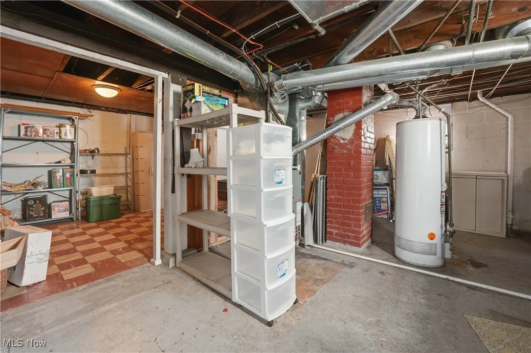 Unfinished basement with water heater and tile patterned floors
