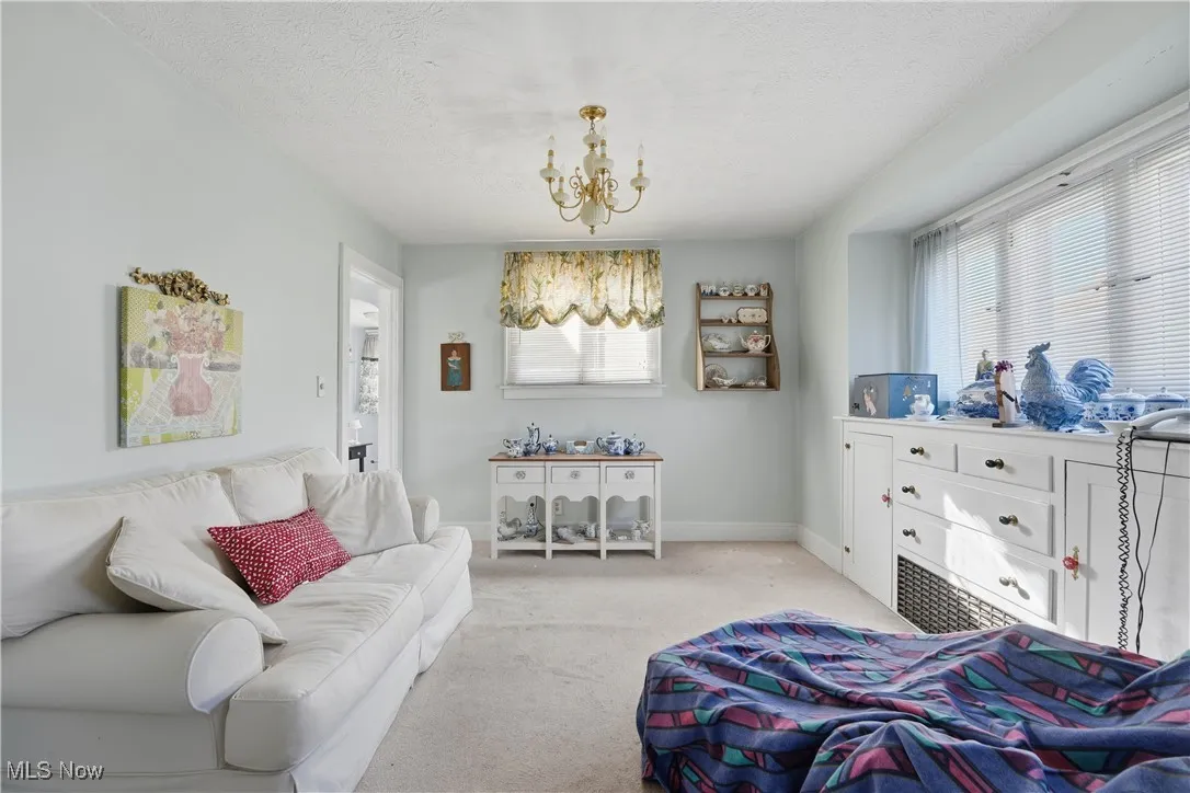 Bedroom with a chandelier, multiple windows, carpet, and a textured ceiling