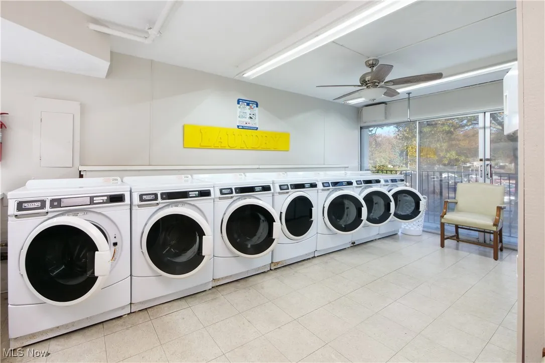 Shared laundry room with washing machine and dryer, ceiling fan, and electric panel