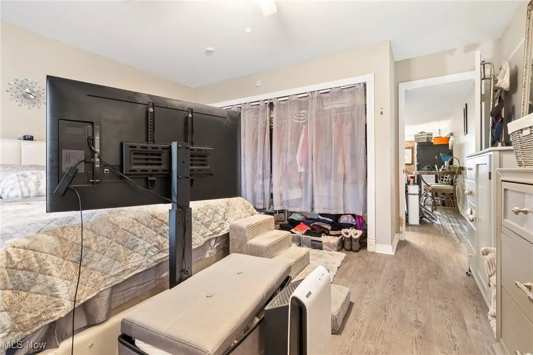 Bedroom with light wood finished floors, a desk, and a ceiling fan