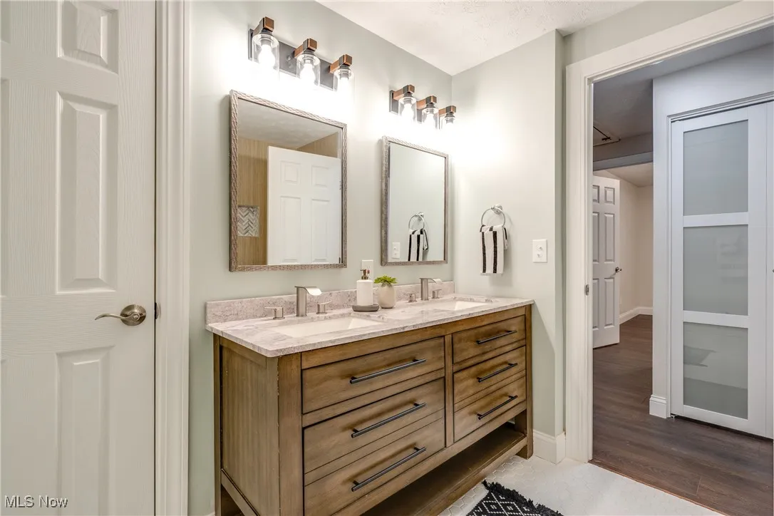 Bathroom featuring double vanity and dark wood finished floors